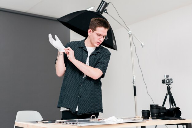 Werkende fotograafmens die zijn witte handschoenen zet