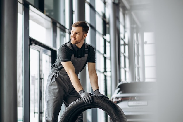 Werkman bij autoreparatiewerkplaats die banden verwisselt