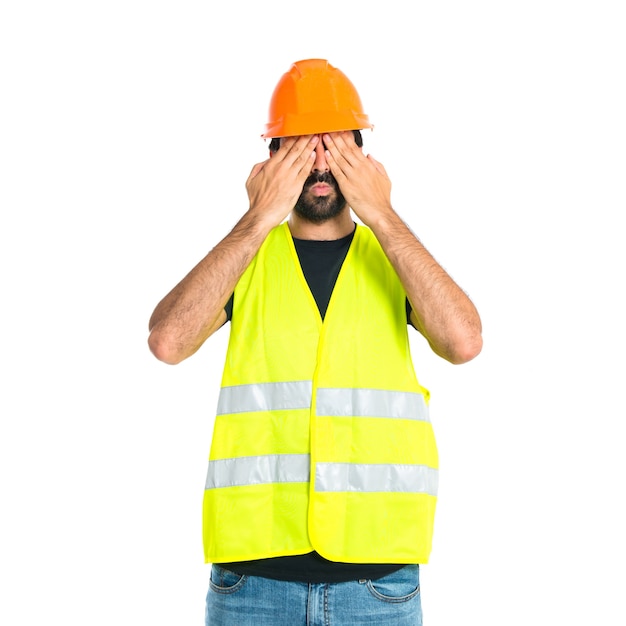 Werkman die zijn ogen over geïsoleerde witte achtergrond bedekt
