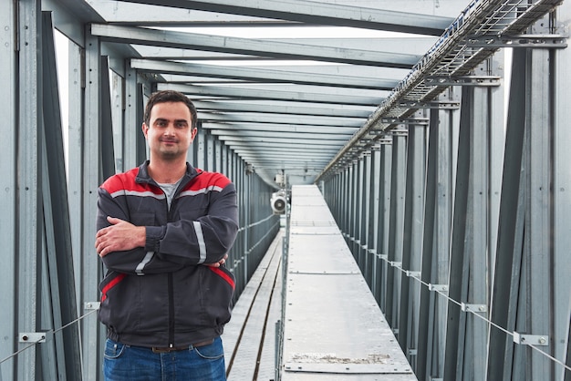 werknemer in uniform tegen de agri-gebouwen op de achtergrond