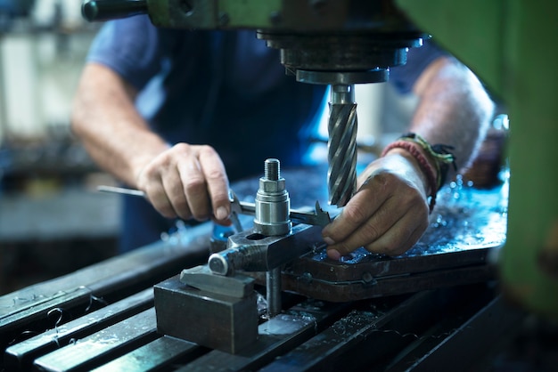 Werknemer industriële machine in metalen werkplaats