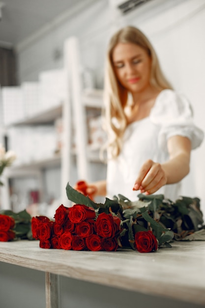 Werknemer met bloemen. Vrouw maakt een boeket. Leuk meisje aan het werk