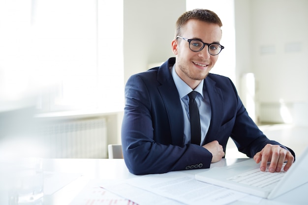 Gratis foto werknemer zitten met laptop