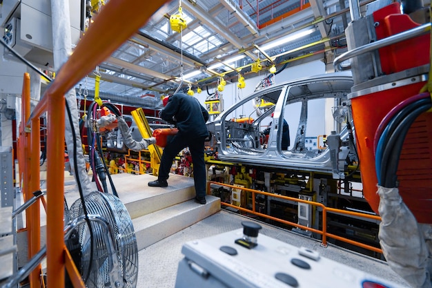 Werknemers assembleren auto moderne geautomatiseerde assemblagelijn voor auto's nieuwste technologisch neutrale technologieën voor de productie van auto's in fabriek Assemblage van auto's op transportband