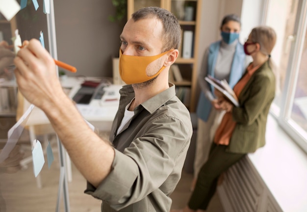 Werknemers die op kantoor gezichtsmaskers dragen