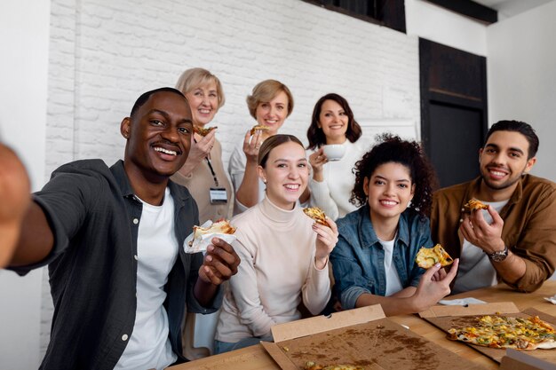 Werknemers eten pizza op het werk.