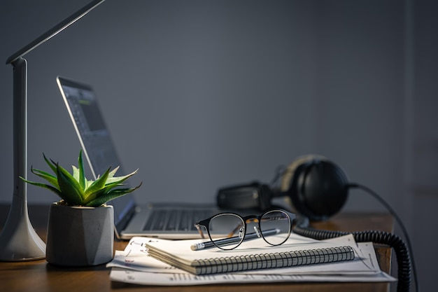 Werkplek met koptelefoon en laptop 's avonds kopieerruimte