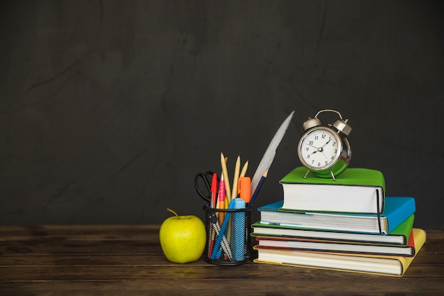 Werkplek met schoolboeken en wekker