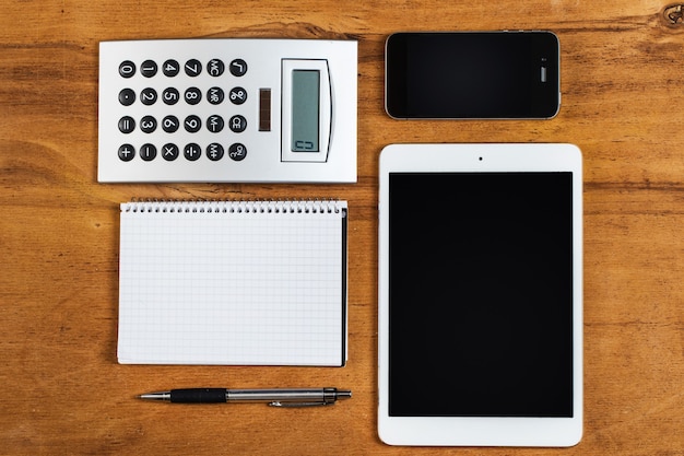 Werkplek. Telefoon, tablet en notitieblok op tafel