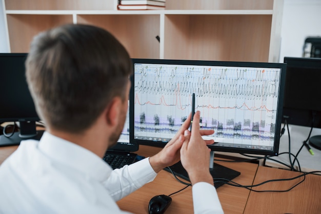 Gratis foto werkproces. polygraaf examinator op kantoor met de apparatuur van zijn leugendetector