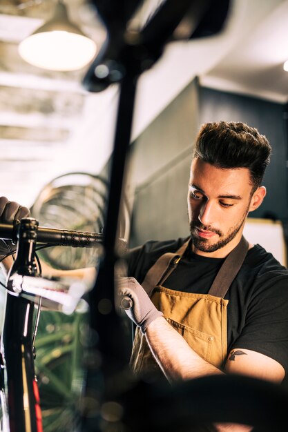 Werktuigkundige die een fiets herstelt