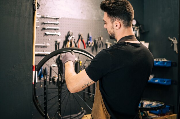 Werktuigkundige die een fiets herstelt