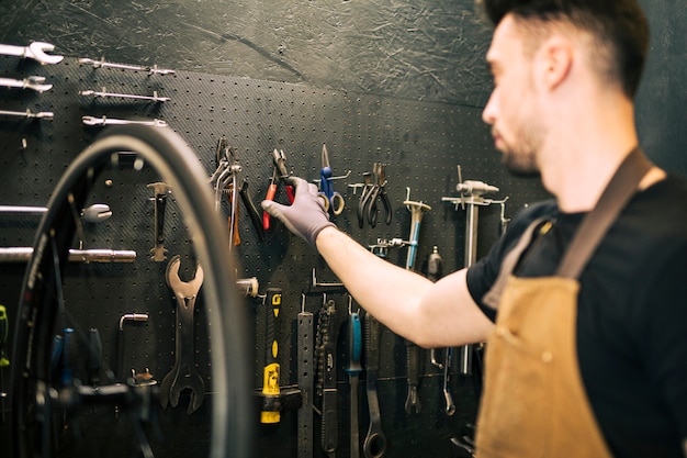 Werktuigkundige die een fiets herstelt