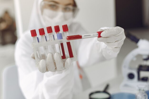 Wetenschapper in speciale apparatuur toont coronavirus testmonster