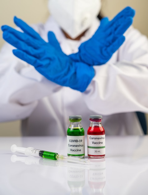 Wetenschappers dragen blauwe handschoenen en maken handen een onaanvaardbaar vaccin om covid-19 te voorkomen