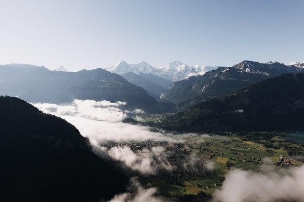 Wide shot van bergen en heuvels omgeven met groene weiden en mist