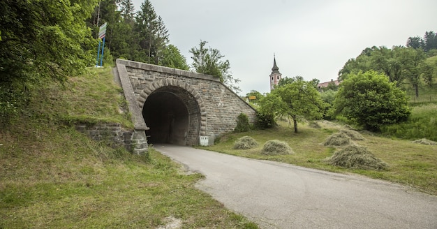 Wide shot van een tunnel van een oude spoorweg in Slovenië op een bewolkte dag