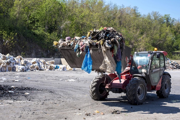 Wiellader die gemeentelijk afval naar de afvalverwerkingsinstallatie vervoert