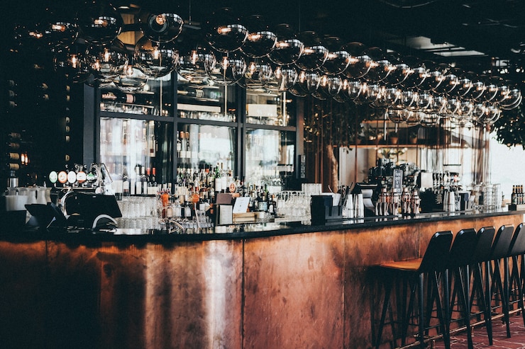 Gratis Foto wijd geschoten van flessen en glazen in vitrinekast bij een bar in scandic hotel in kopenhagen, denemarken