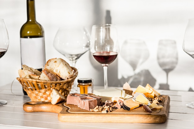 Wijn, stokbrood en kaas op houten