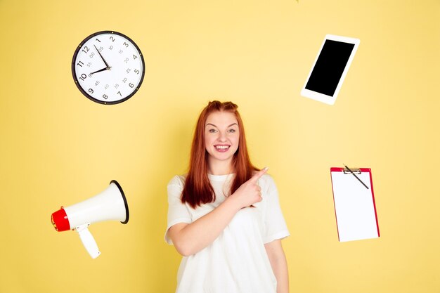 Wijzen, kiezen. Het portret van de Kaukasische jonge vrouw op gele studio