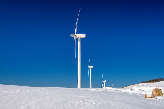 Gratis foto windturbine en blauwe hemel in winterlandschap
