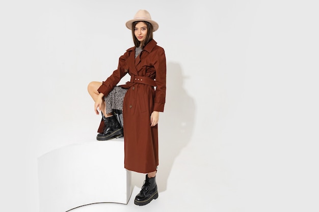 Winer fashion look. Stijlvol brunette model in bruine jas en beige hoed poseren