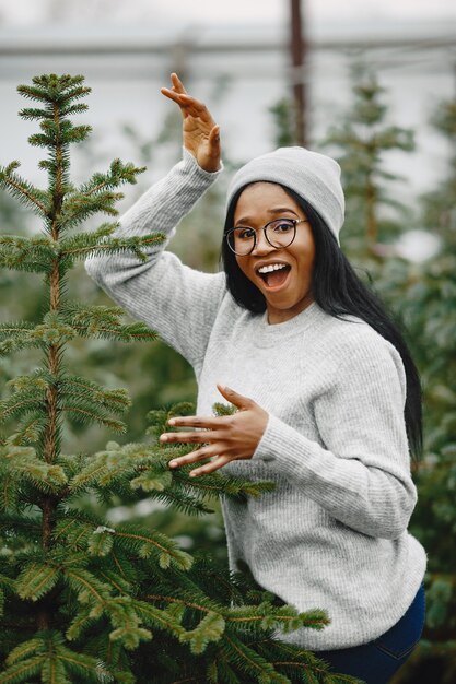 Winterconcept. Vrouw in een grijze trui. Verkoopster van kerstboom.