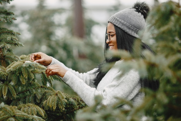 Winterconcept. Vrouw in een grijze trui. Verkoopster van kerstboom.