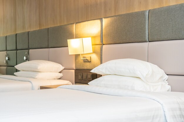 Wit comfortabel kussen en deken op bed met lichte lamp