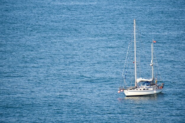 Witte boot die overdag in de vredige zee vaart