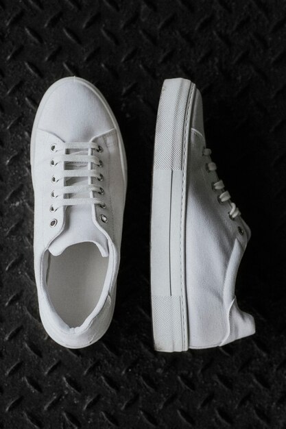 Witte canvas sneakers op metalen vloer