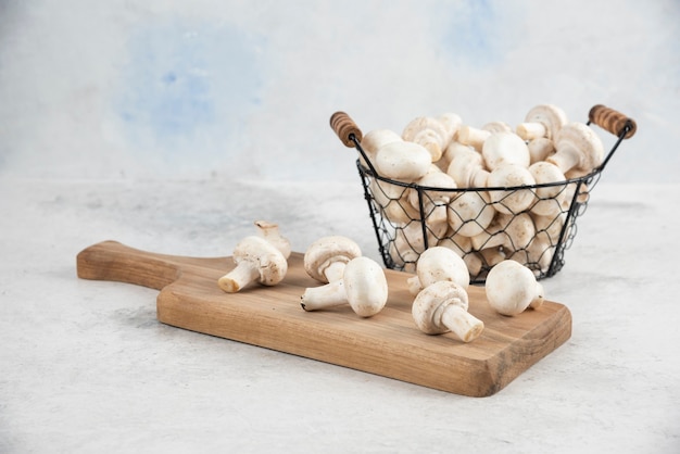 Witte champignons in een metalen dienblad op een houten schotel.