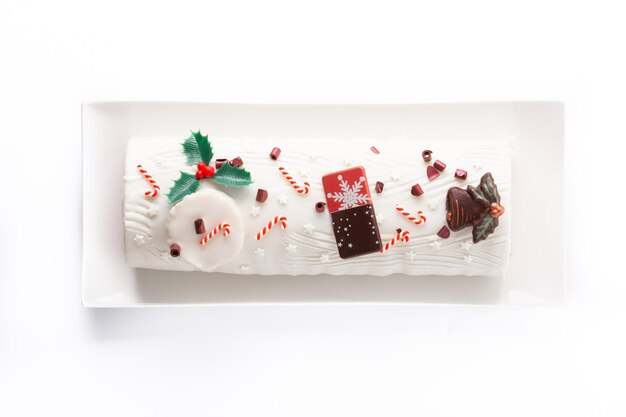 Witte chocolade yule log cake met kerst ornament geïsoleerd op een witte achtergrond