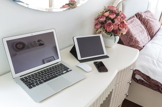 Witte desktop met laptop en tablet