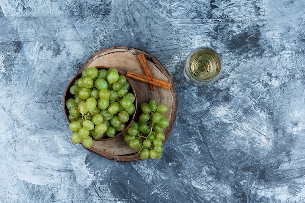 Witte druiven, kaneel op een houten bord met glas whisky bovenaanzicht op een donkerblauwe marmeren achtergrond