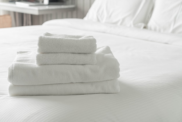 Witte handdoek op beddecoratie in slaapkamer interieur