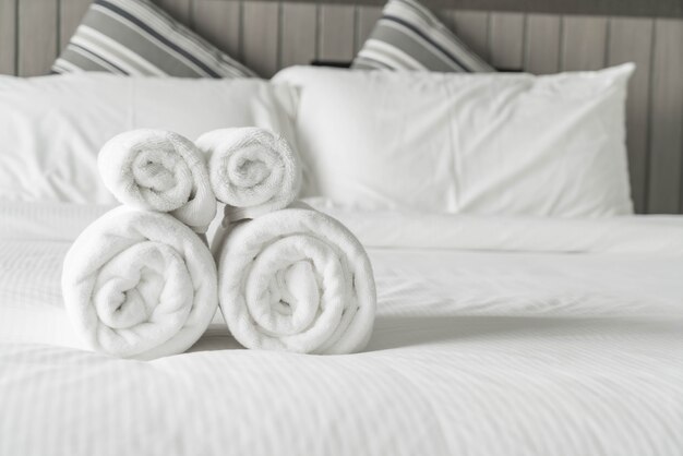 Witte handdoek op beddecoratie in slaapkamer interieur