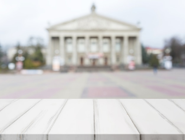 Witte houten tafel voor wazig klassieke openbare gebouwen fa�ade