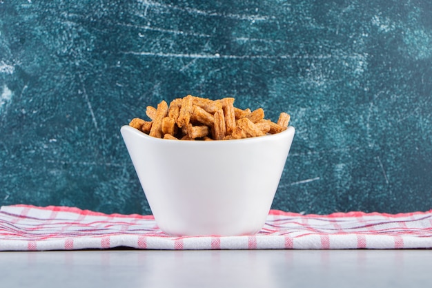 Witte kom krokante stokcrackers op steen.