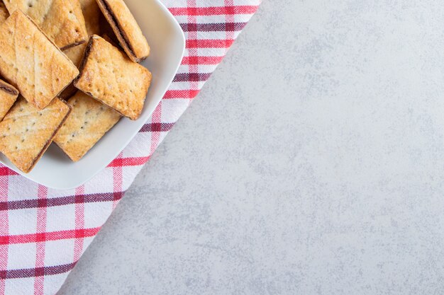 Witte kom smakelijke krokante crackers op stenen achtergrond.