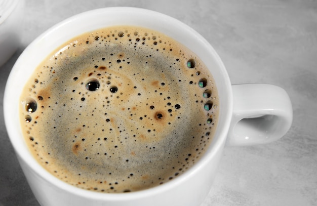Witte kop zwarte koffie van bovenaf. bovenaanzicht van koffiebel close-up