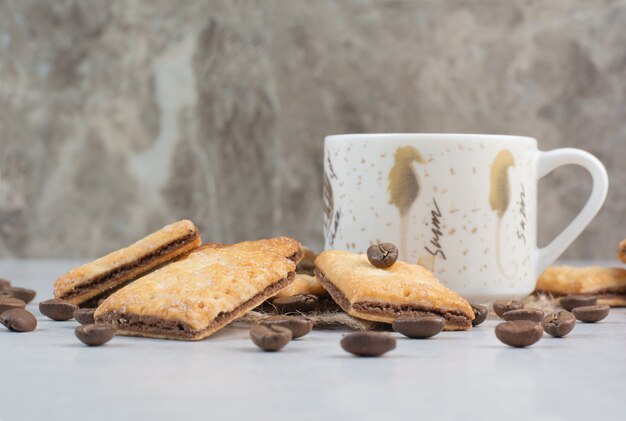Witte kopje koffie met crackers en koffiebonen op witte achtergrond. Hoge kwaliteit foto