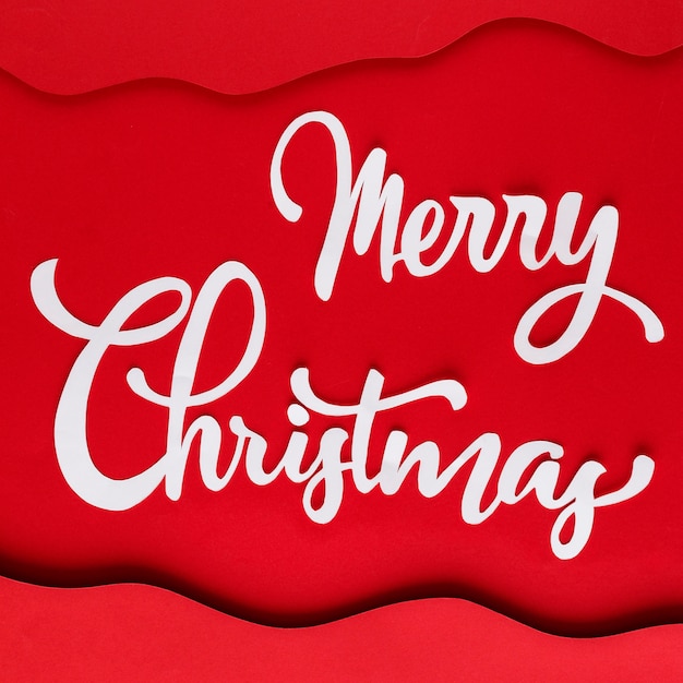 Gratis foto witte merry christmas letters op rood papier met lagen