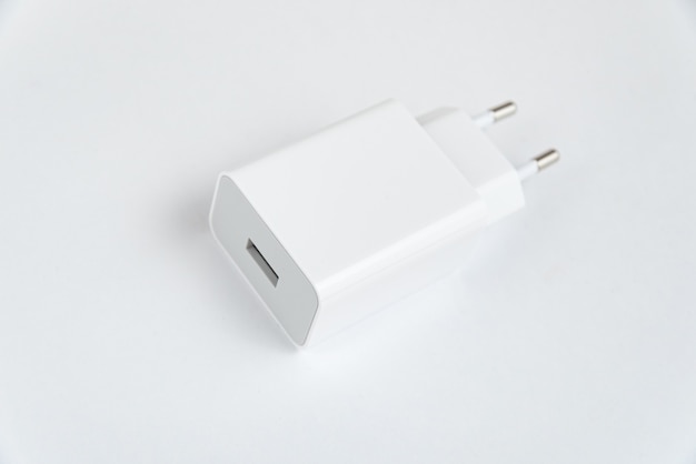Witte mobiele telefoonoplader op de witte geïsoleerde achtergrond