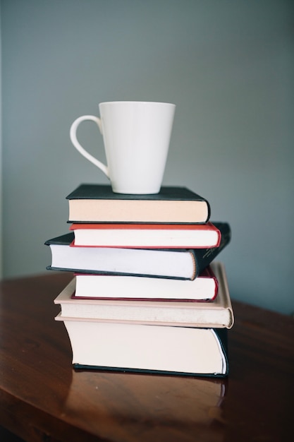 Gratis foto witte mok op stapel boeken