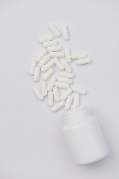 Gratis foto witte pillen en container
