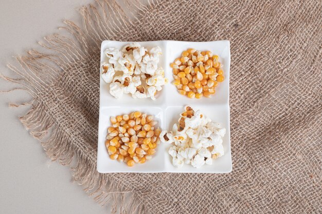 Witte pluizige popcorns in een ceramische kop op beton.