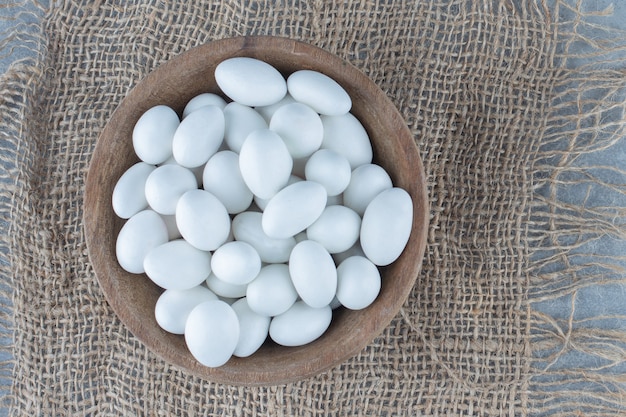 Witte snoepjes in de beker op de onderzetter, op de marmeren tafel.