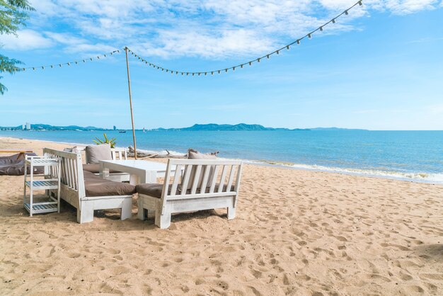 Gratis foto witte stoelen en tafel op het strand